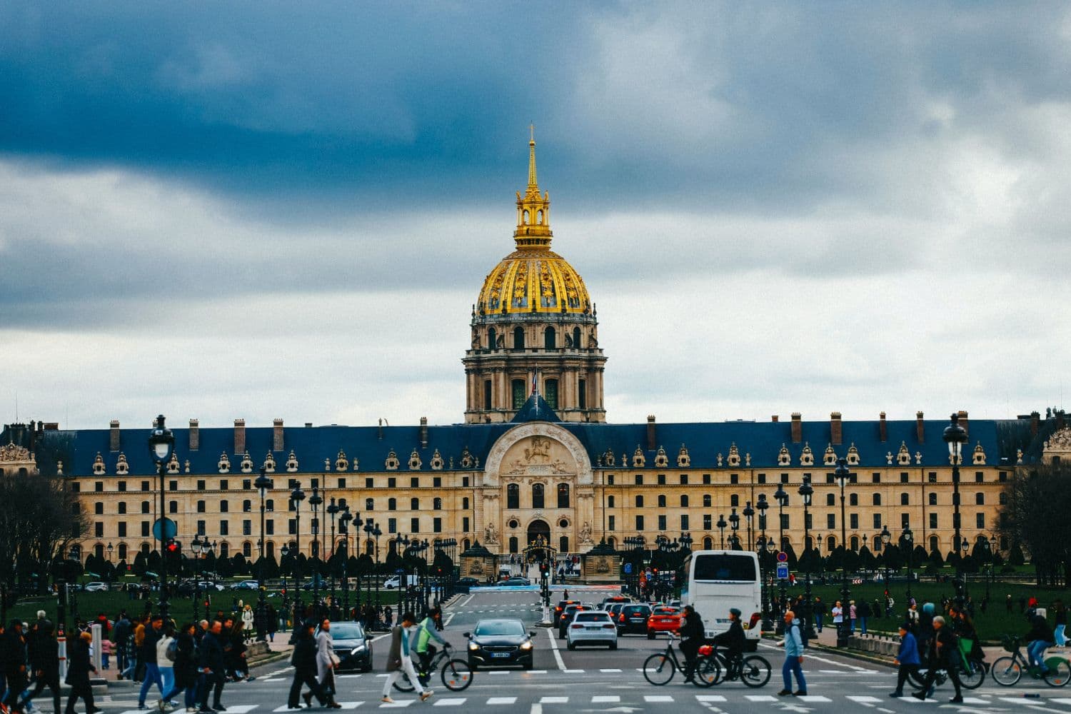 Dôme des Invalides de face par temps gris, voitures, vélos et piétons au premier plan