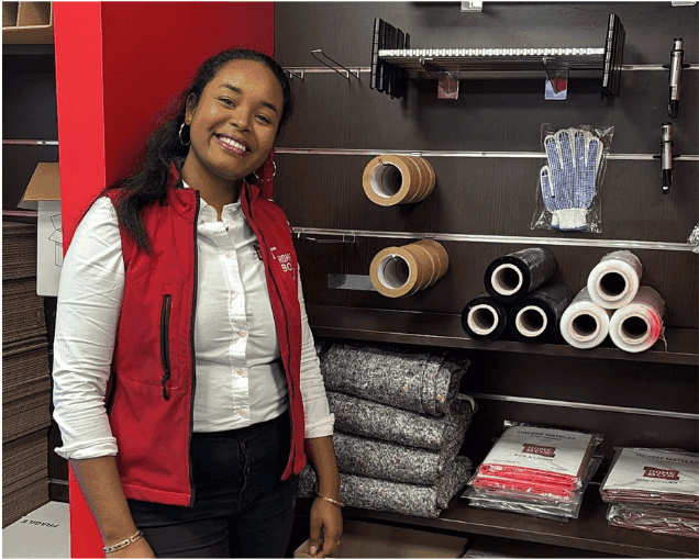 Conseillère HOMEBOX en gilet rouge devant un présentoir d'accessoires de déménagement du centre HOMEBOX Linas Montlhéry