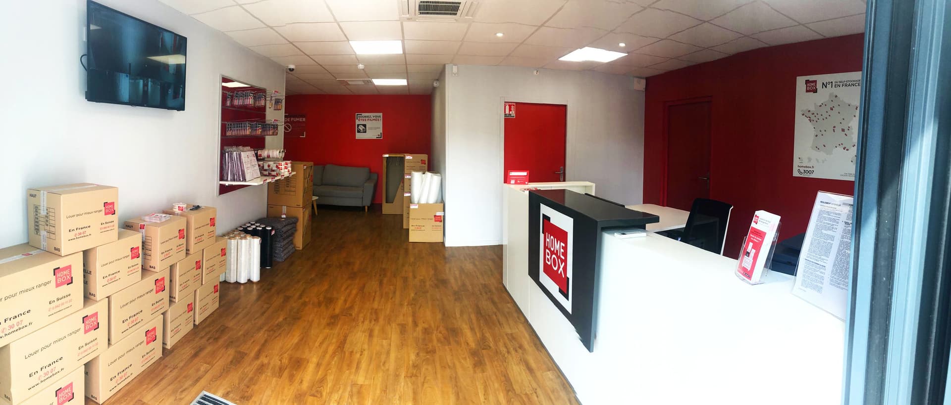 Espace accueil avec comptoir, cartons d'emballage et carte de France du centre HOMEBOX Orléans Sud