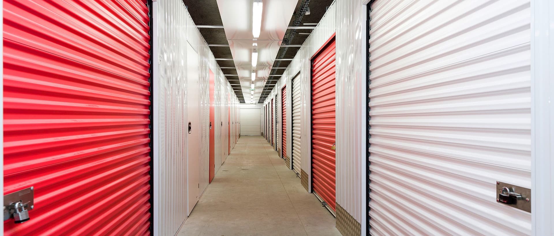 Couloir intérieur avec portes de boxes rouges et blanches alignées du centre HOMEBOX Niort