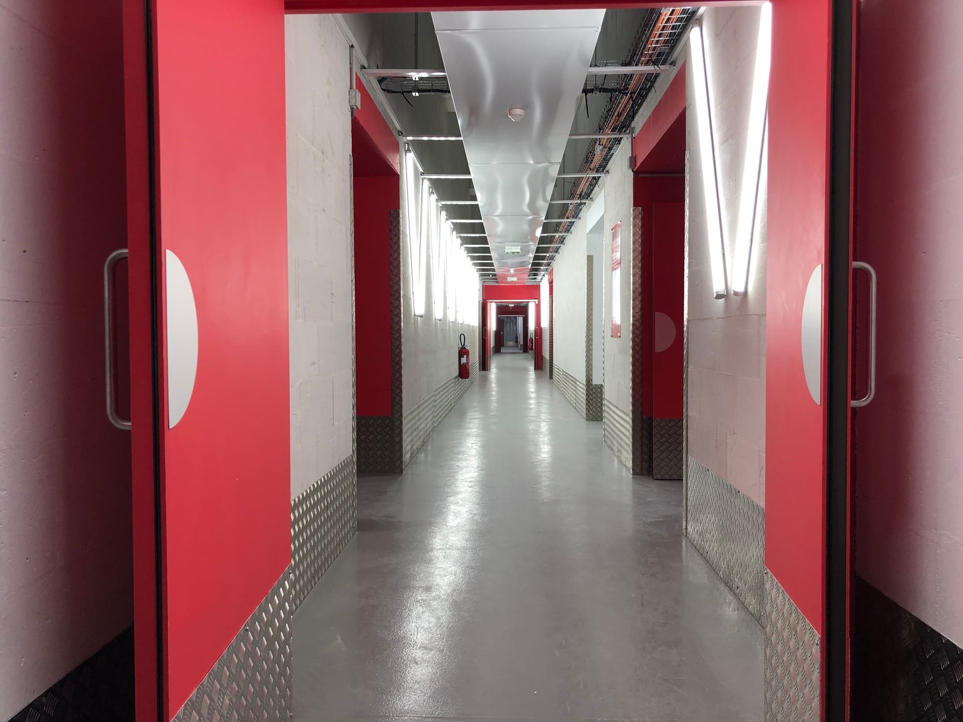 Couloir intérieur rouge et blanc avec sol béton lisse du centre HOMEBOX Paris 16