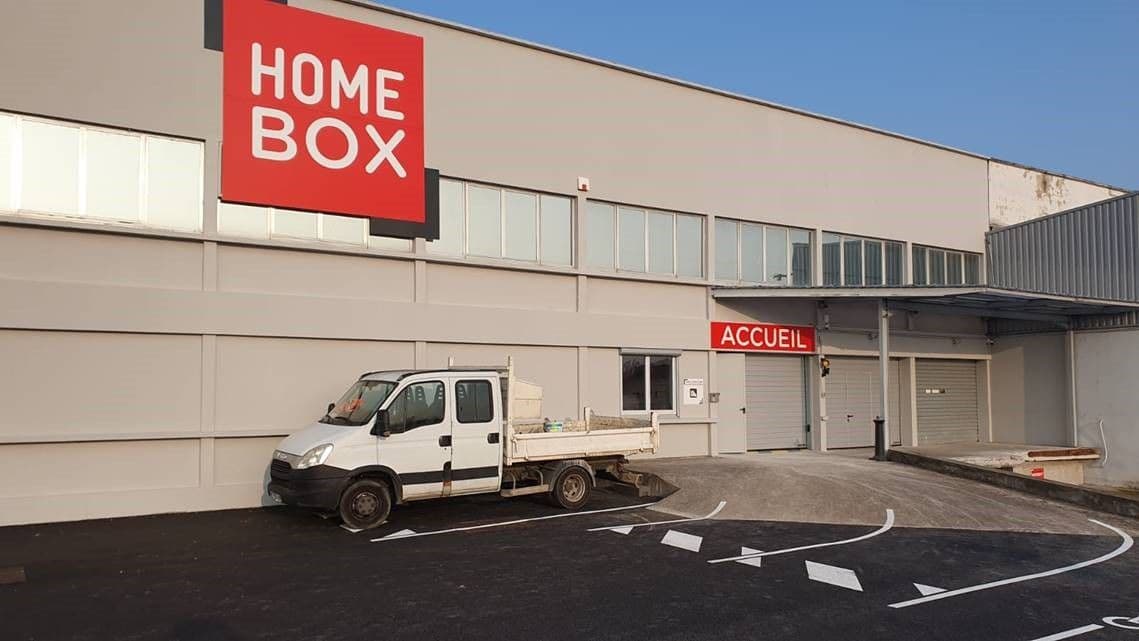 Façade du centre avec enseigne HOMEBOX et camion benne devant l'accueil, HOMEBOX Roanne, 213 Rue de Charlieu à Roanne