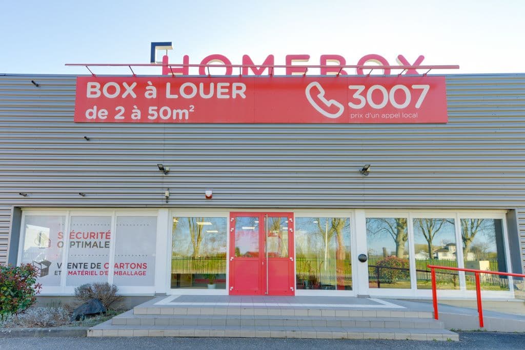 Entrée vitrée du centre avec enseigne Homebox lumineuse et bandeau rouge tarifaire, HOMEBOX Strasbourg, 8 rue du Doubs à Strasbourg