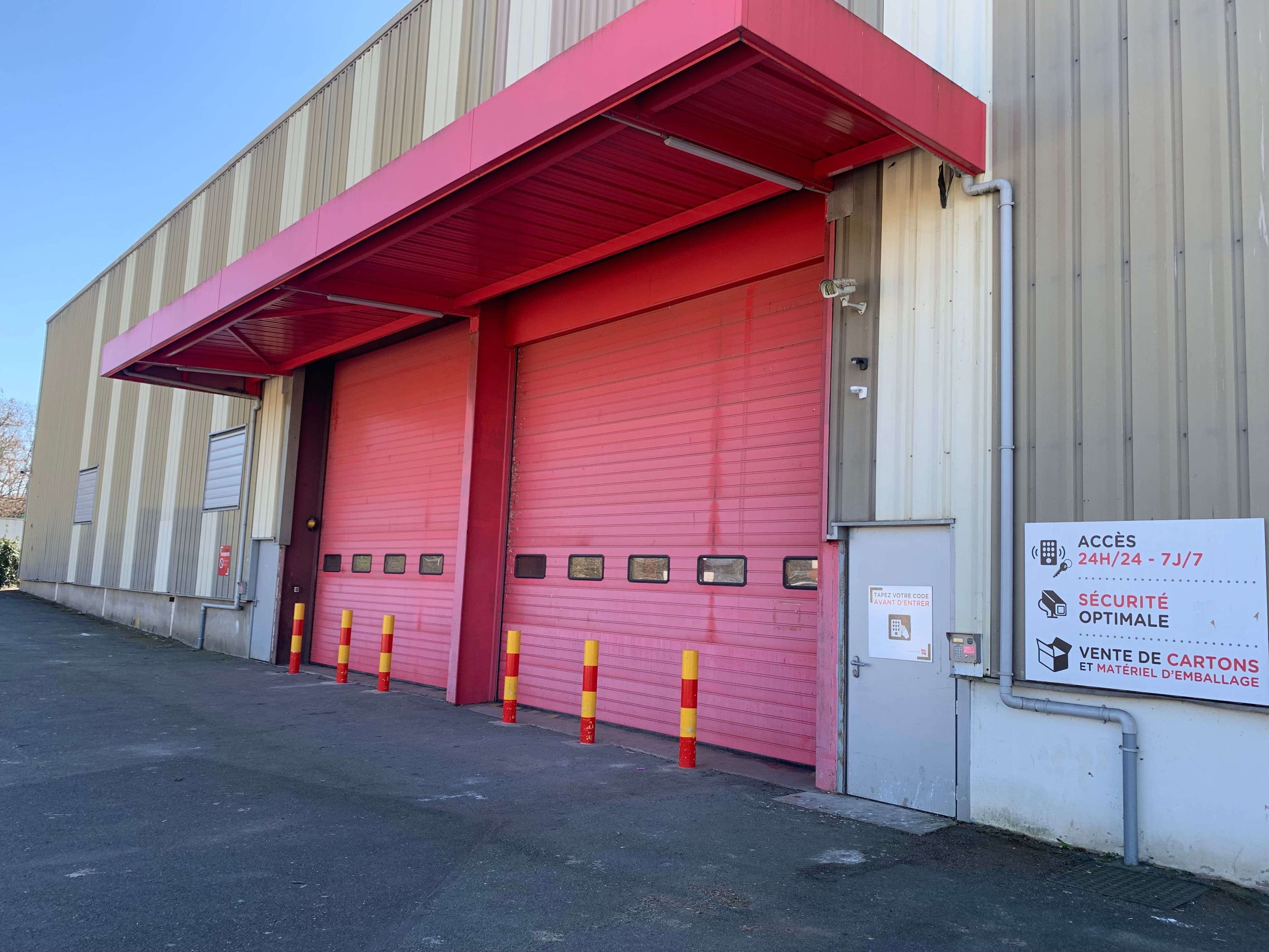 Vue des grandes portes rouges du centre HOMEBOX Franconville permettant le chargement et déchargement.