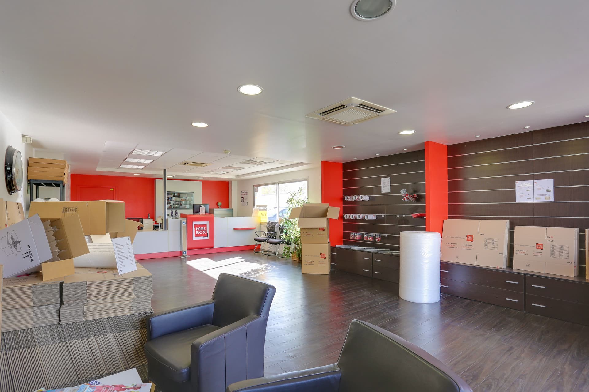 Espace boutique avec fauteuils, cartons et présentoir de fournitures de déménagement du centre HOMEBOX Rennes Sud