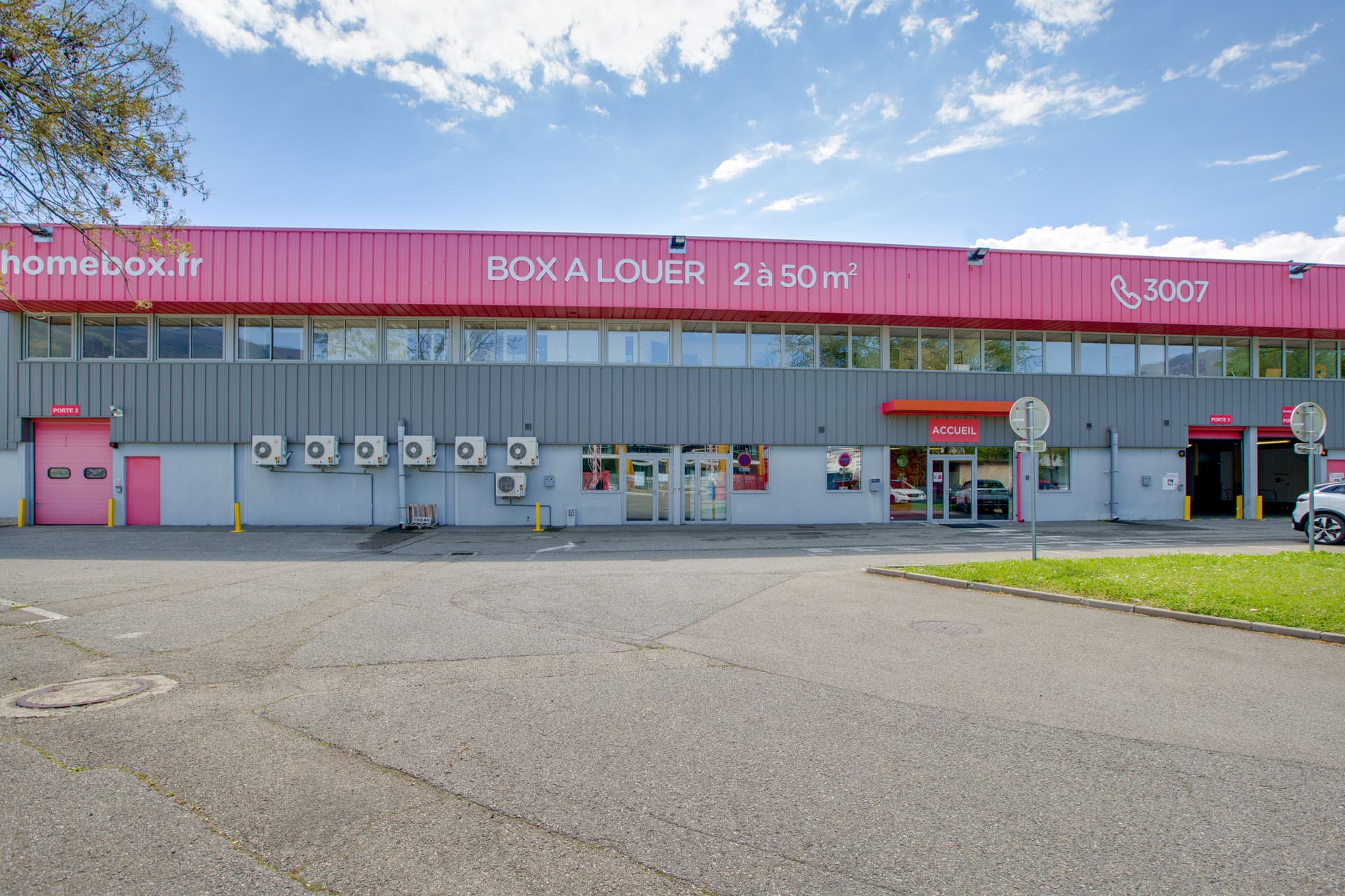 Vue extérieure du centre HOMEBOX Grenoble, 25 rue du Moucherotte, avec parking et enseigne HOMEBOX.