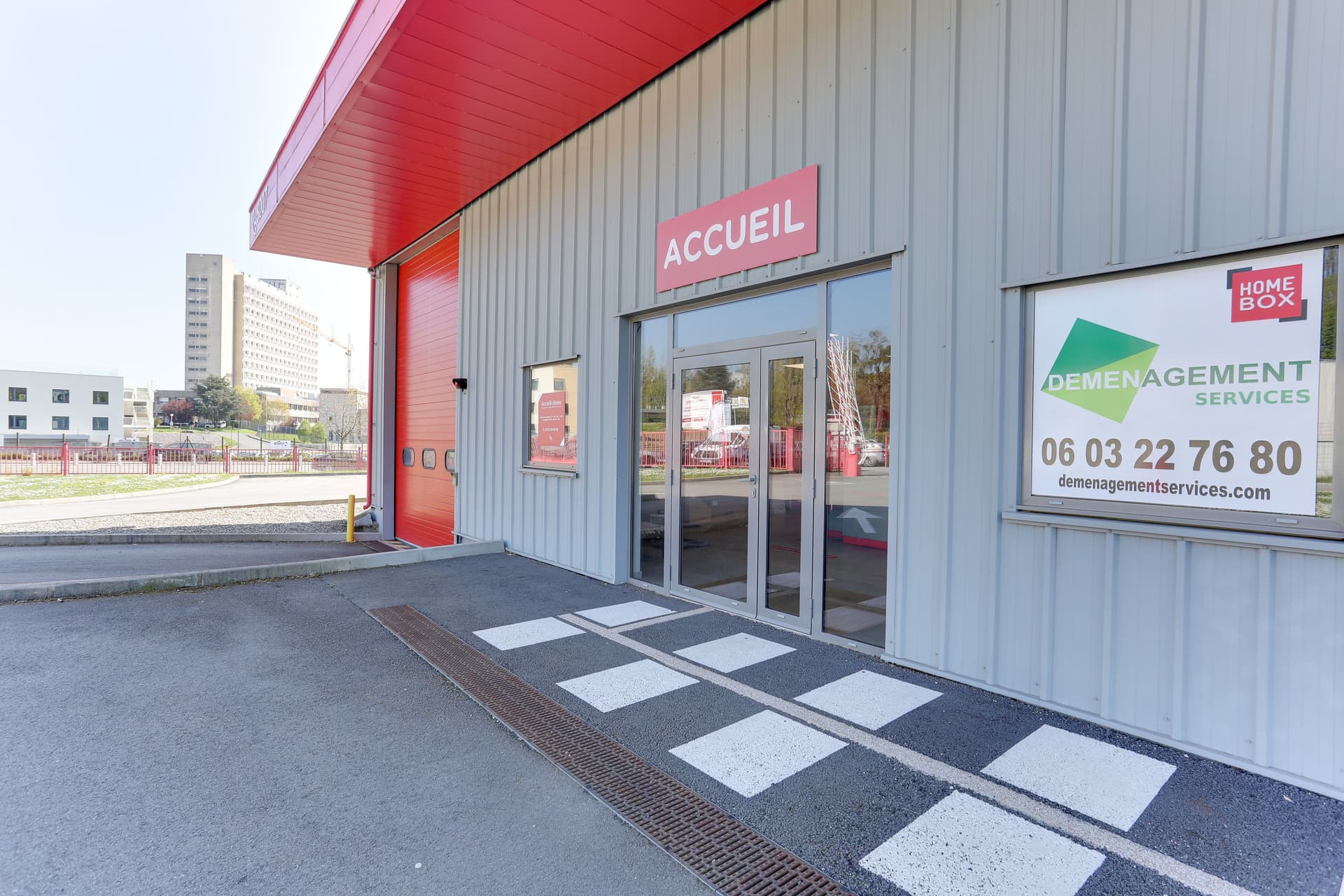 Entrée vitrée Accueil avec auvent rouge et vitrophanie partenaire, HOMEBOX Laval, 19 boulevard du 8 mai 1945 à Laval