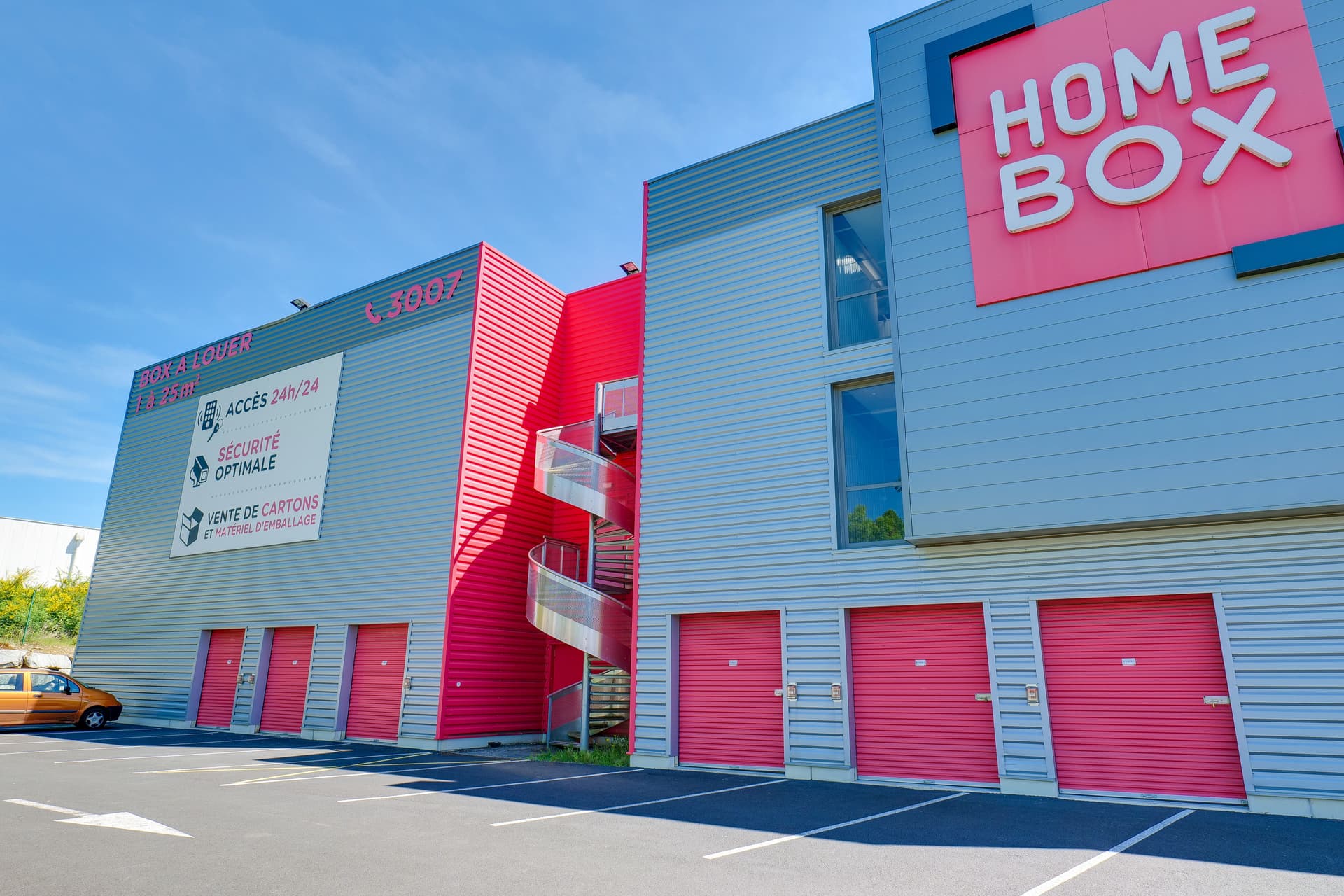 Bâtiment gris avec grande enseigne HOMEBOX et escalier hélicoïdal rouge, HOMEBOX Limoges, 8 Allée Louis Daubenton ZAC Beaubreuil à Limoges
