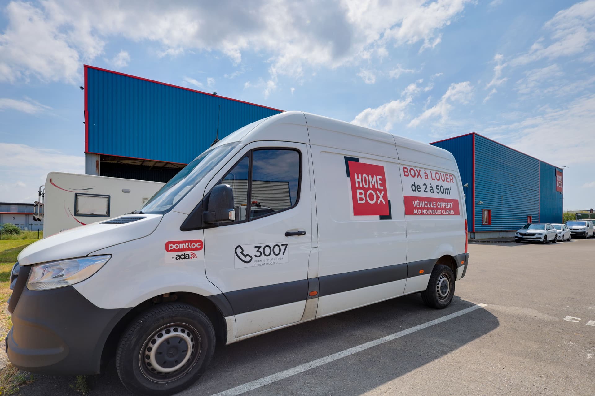 Camion blanc HOMEBOX avec marquage location stationné devant le bâtiment, HOMEBOX Nanteuil - Dammartin, Allée des Primevères à Nanteuil - Le - Haudoin