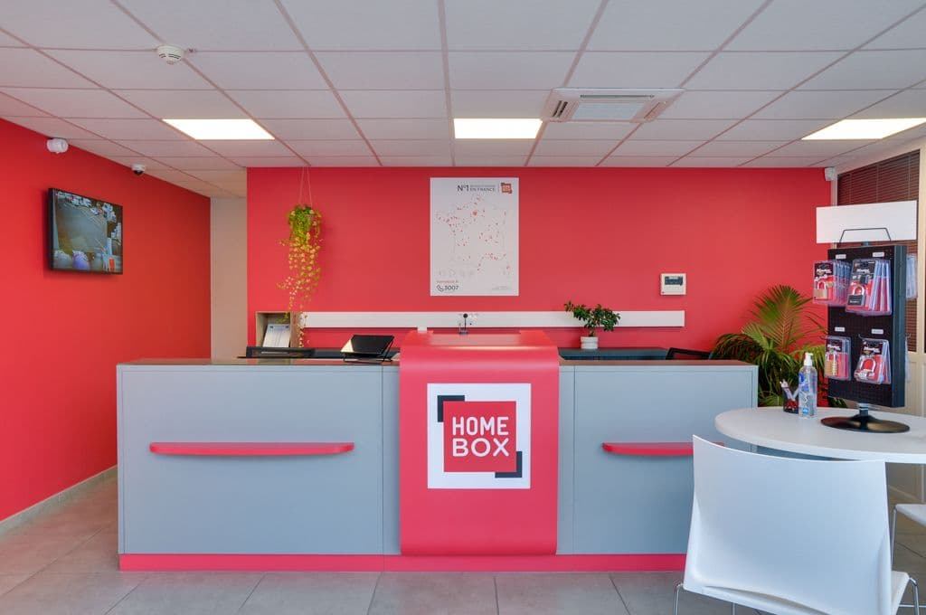 Comptoir d'accueil bleu et rouge avec logo et carte de France des centres du centre HOMEBOX Saint-Etienne