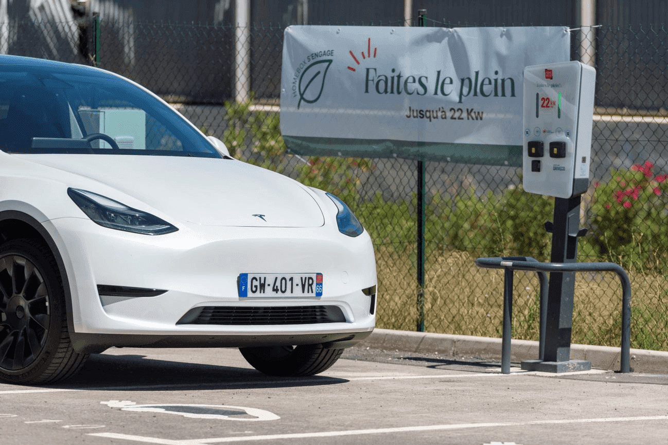 Borne de recharge électrique avec voiture Tesla blanche sur le parking, HOMEBOX Perpignan, Zone Polygone Nord - 430 rue Louis Delage à Perpignan