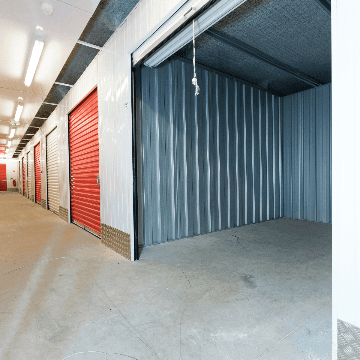 Couloir intérieur avec box ouvert et rangées de portes rouges du centre HOMEBOX Cherbourg