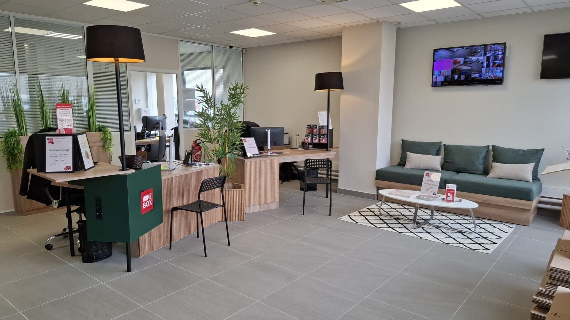 Espace d'accueil moderne avec comptoir, bureaux et coin salon du centre HOMEBOX Lyon Décines-Villeurbanne